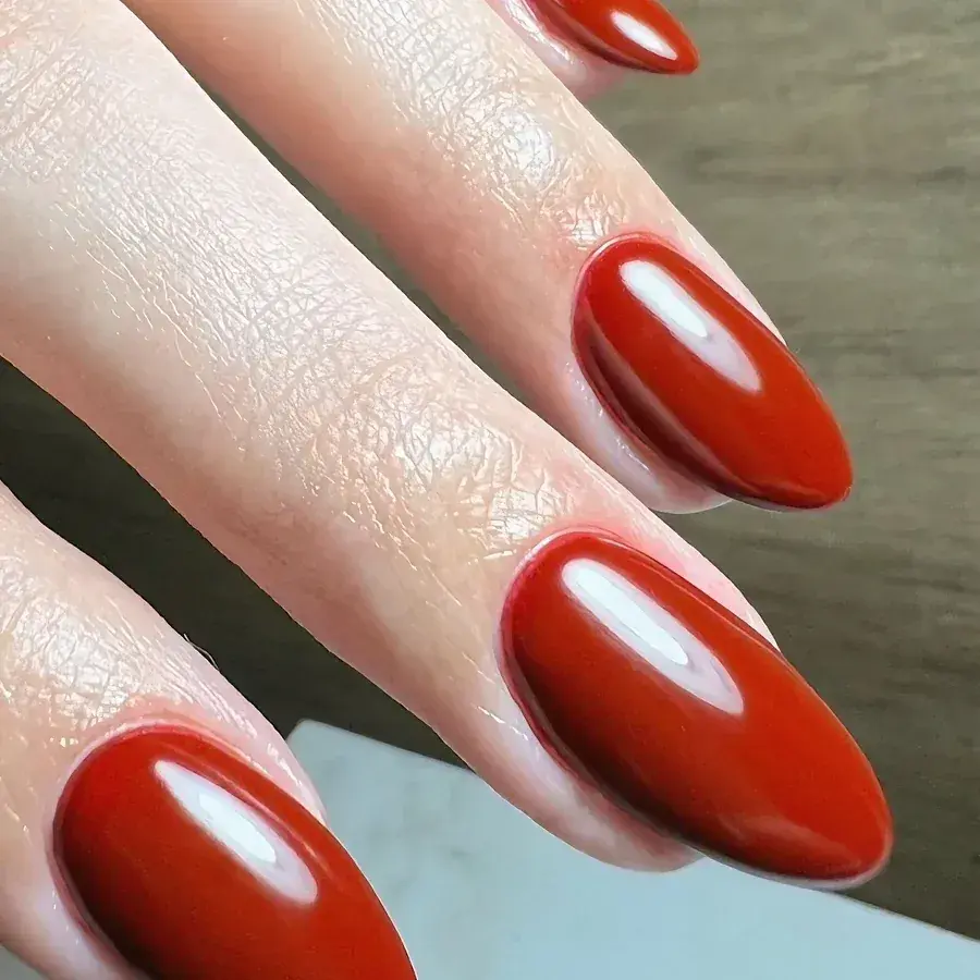 Post de Grazi Sturion com unhas amêndoa em vermelho terracota